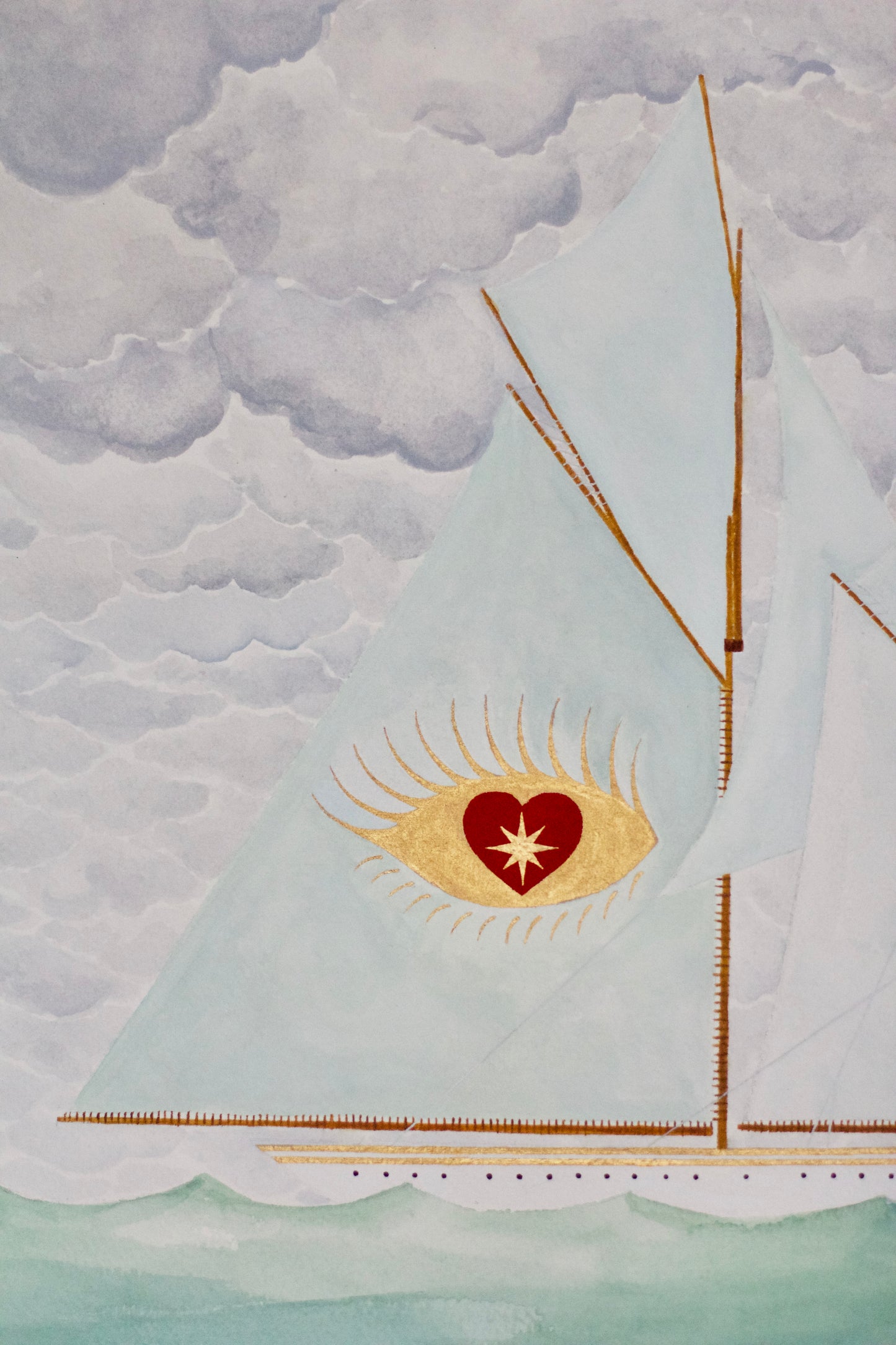 Sailboat with blue sails, golden eye and red heart emblem on cloudy sea.